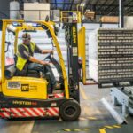 Persoon aan het werk in de Nederlandse maakindustrie, benadrukt kwetsbaarheid voor cyberaanvallen en het belang van cybersecurity.
